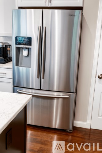 A stainless steel refrigerator with a water dispenser on the door.