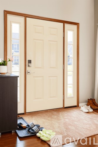 A pair of shoes and a bag are on the floor by the door.