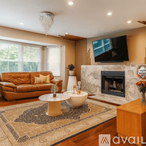 A living room with a fireplace and a television mounted above it.