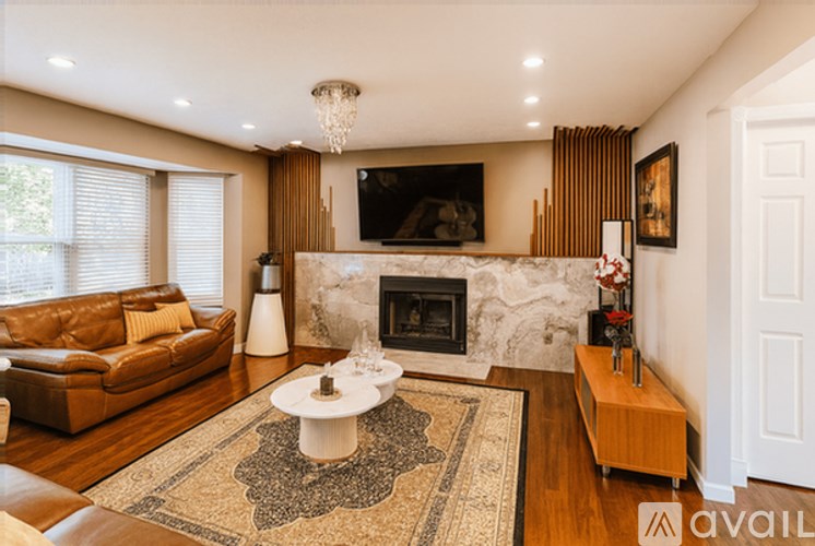 A living room with a fireplace and a television mounted above it.