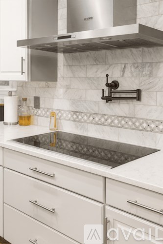 A living room with a brown couch and a staircase.