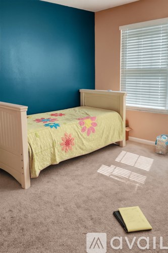 A patio with a table and chairs is surrounded by a grassy area and trees.