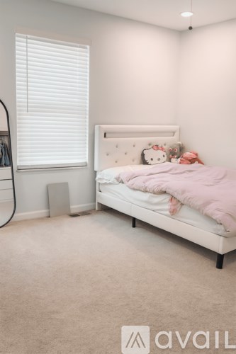 A bedroom with a bed, pillow, and a pink blanket.