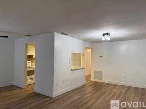 A room with wooden floors and a balcony with a railing.