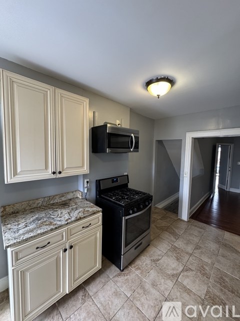 A kitchen with a black stove and white cabinets.