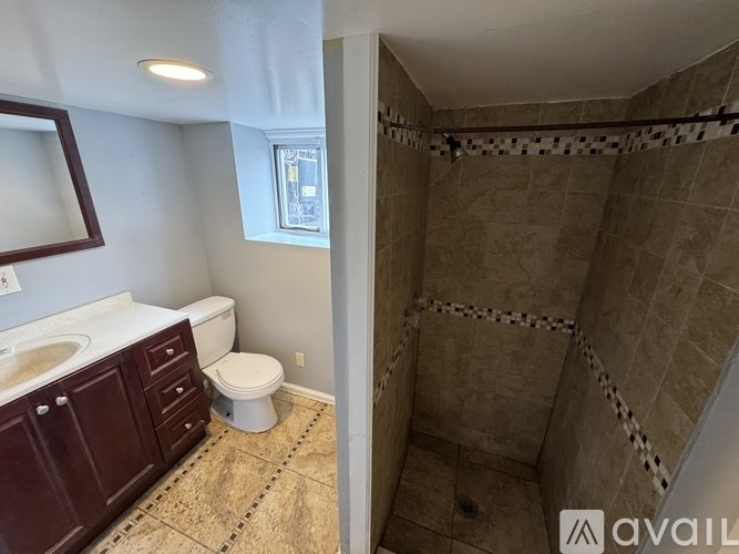 A bathroom with a toilet, sink, and shower.