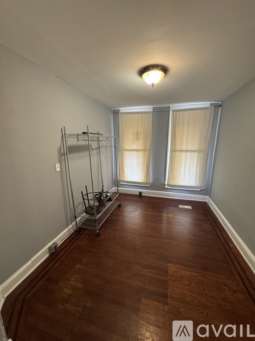 A room with wooden floors and a clothes drying rack.