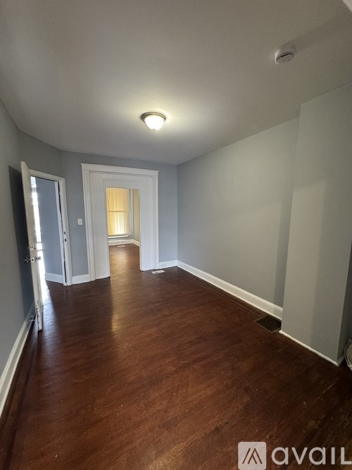A hallway with wood floors and white walls.