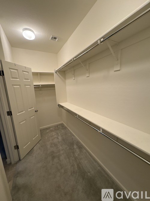 A small, empty room with a door and a wall-mounted coat rack.