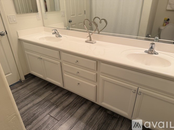A bathroom with two sinks and a large mirror.