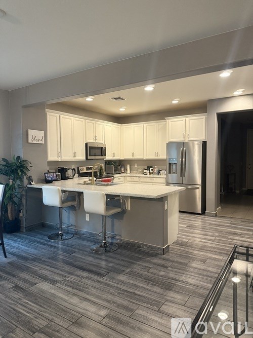 A modern kitchen with a large island and stainless steel appliances.