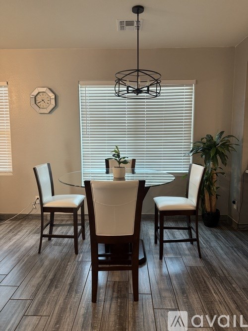 A dining room with a glass table and chairs.