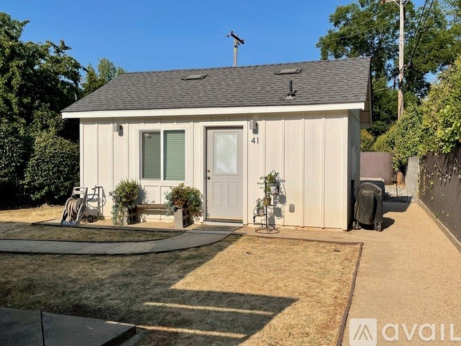 A small house with a white door and a grey roof.