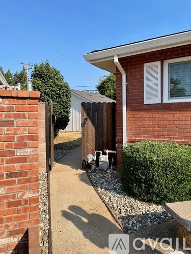 A red brick house with a white window and a brown door.