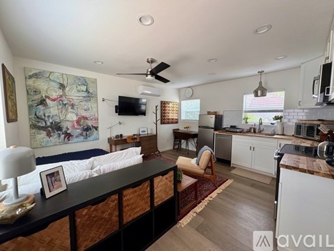 A living room with a couch, a television, and a painting on the wall.