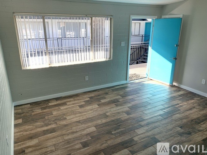 A room with a wooden floor and a blue door.