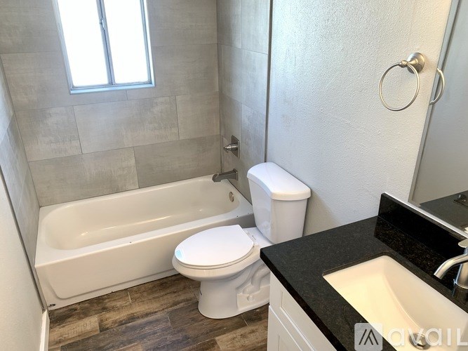 A white toilet sits next to a bathtub in a bathroom.
