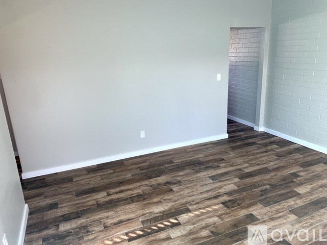 A room with wooden flooring and white walls.