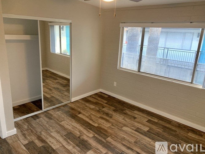 A room with a sliding door and a window with a view of a balcony.