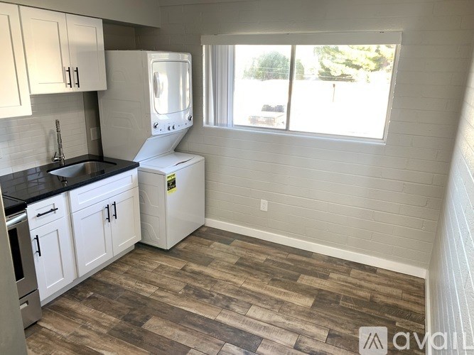 A kitchen with white cabinets and a black countertop.