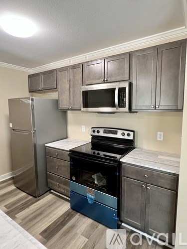 A kitchen with a refrigerator, oven, and microwave.