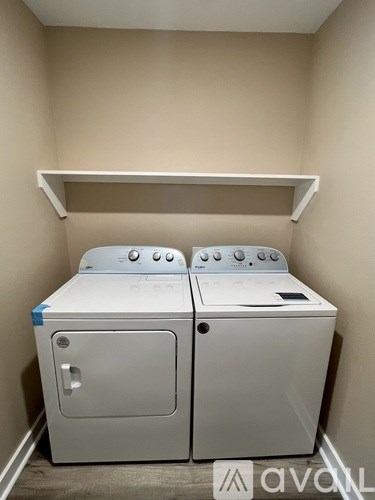 A white washing machine and dryer in a small room.