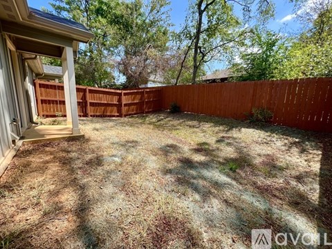 A backyard with a wooden fence and a shed.