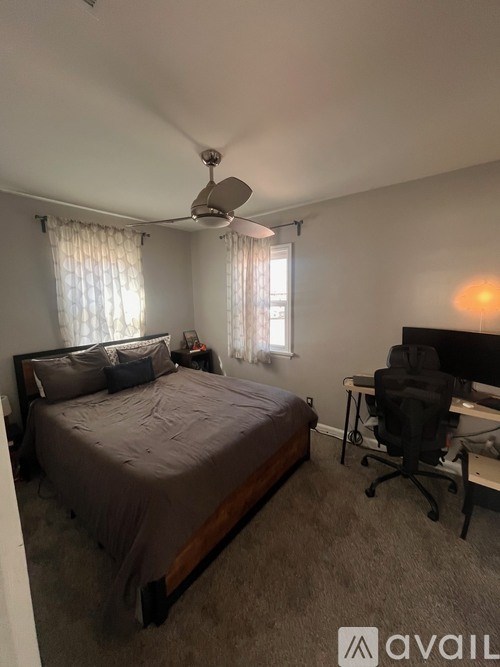 A bedroom with a bed, desk, and chair.