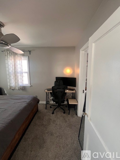 A bedroom with a bed, desk, and chair.