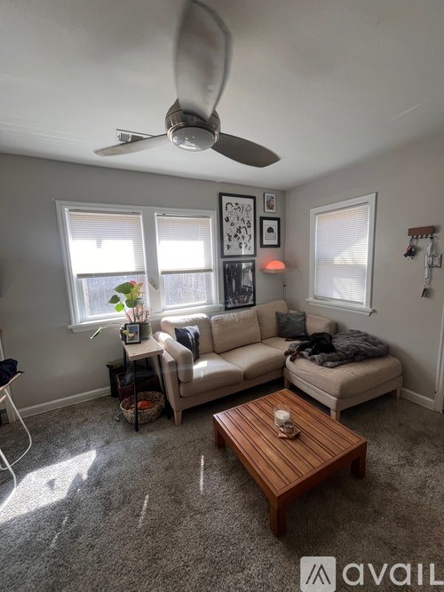 A living room with a fan, two couches, and a coffee table.