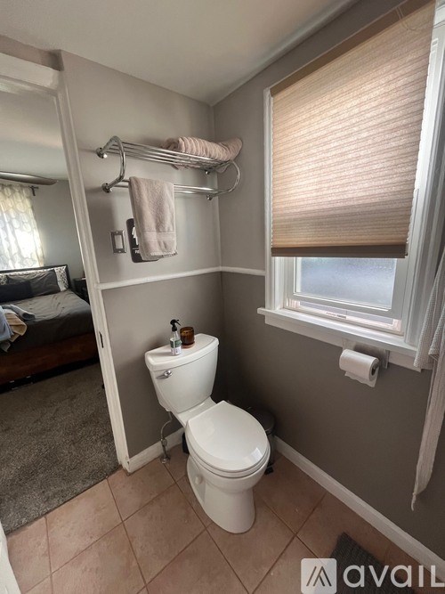 A small bathroom with a toilet and a towel rack.