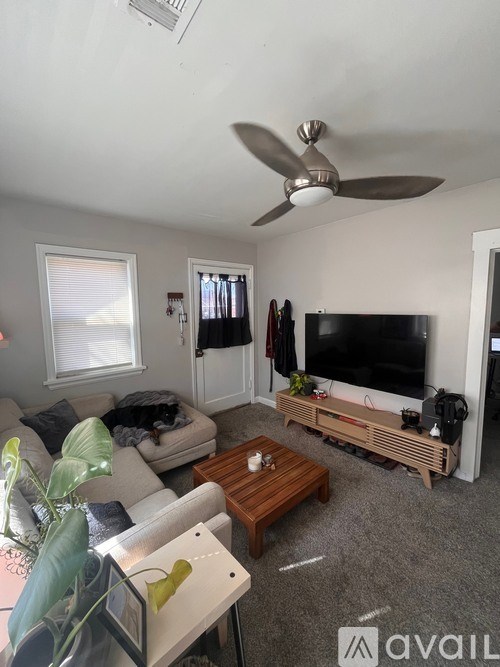 A living room with a television, a couch, and a coffee table.