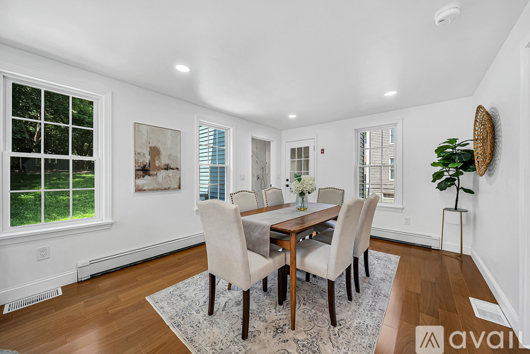 A dining room with a wooden table and chairs.