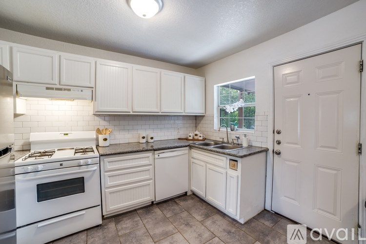 A kitchen with white cabinets and a stove top oven.