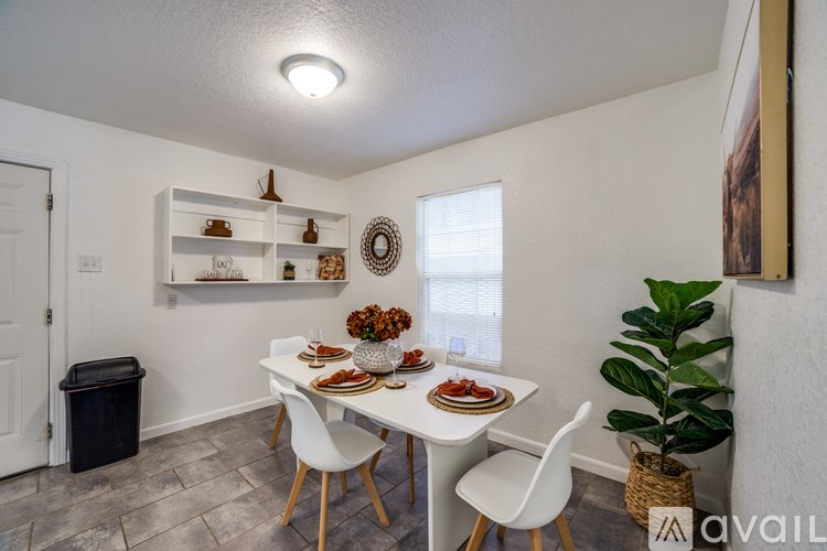 A dining room with a white table and chairs.