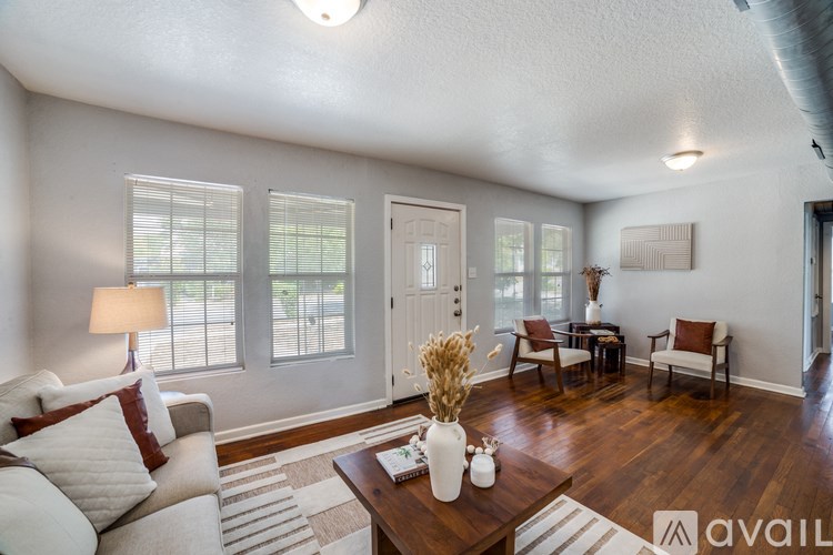 A living room with a white couch and a wooden coffee table.