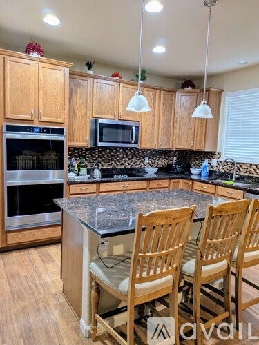 A kitchen with wooden cabinets and a granite countertop.