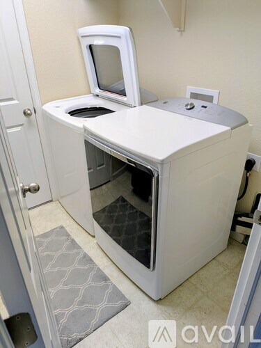 A white microwave oven with a glass door is in a kitchen.