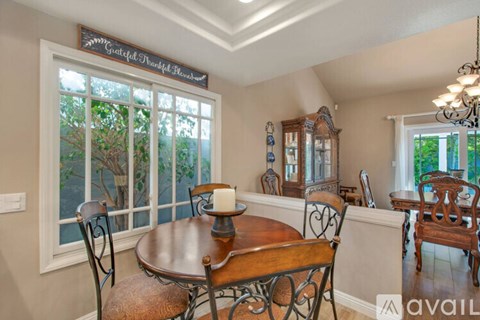 A dining room with a wooden table and chairs.