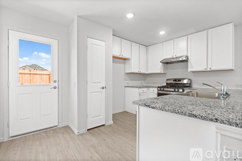 A kitchen with white cabinets and a granite countertop.