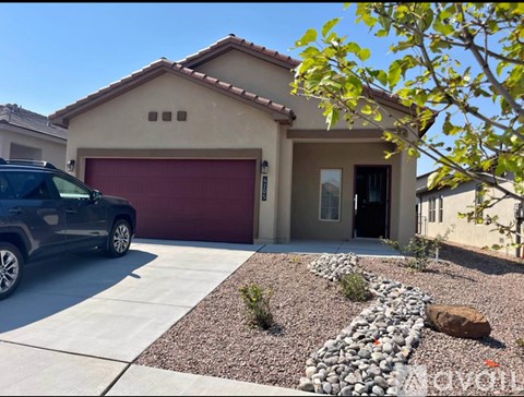 A house with a red garage door and a black car parked in front.
