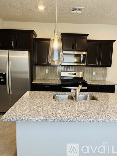A kitchen with granite countertops and stainless steel appliances.