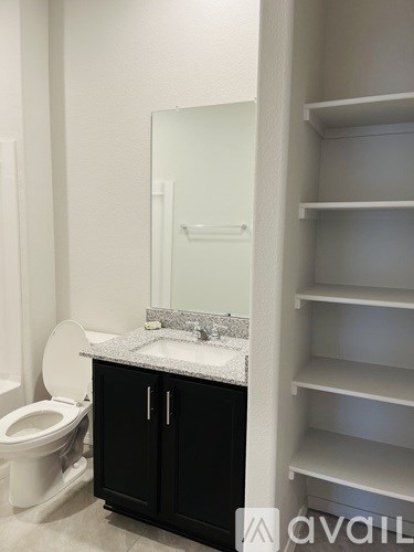 A bathroom with a toilet, sink, and medicine cabinet.