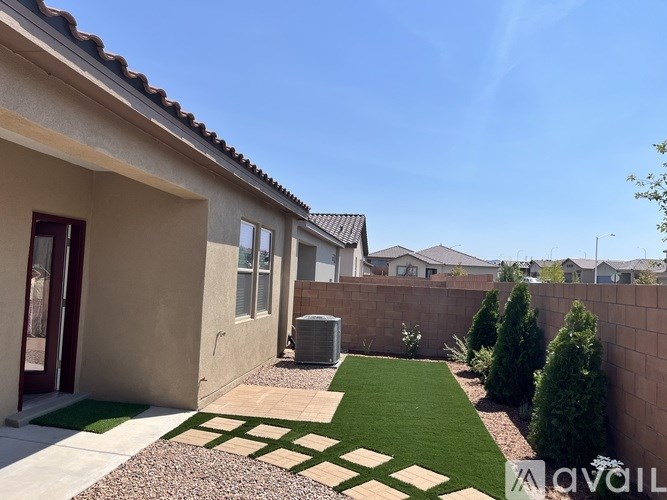 A house with a brown roof and a green lawn in front.