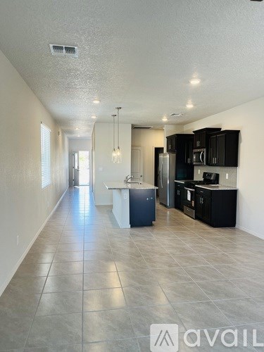 A kitchen area with a refrigerator, microwave, and cabinets.