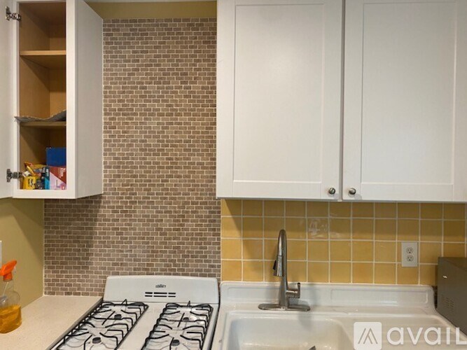 A kitchen with white cabinets and a white stove top oven.