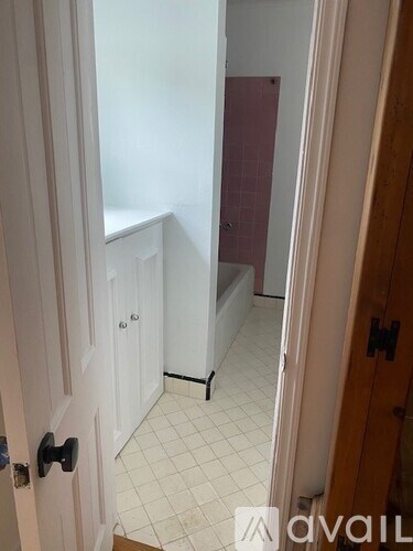 A white door with a black handle is open.