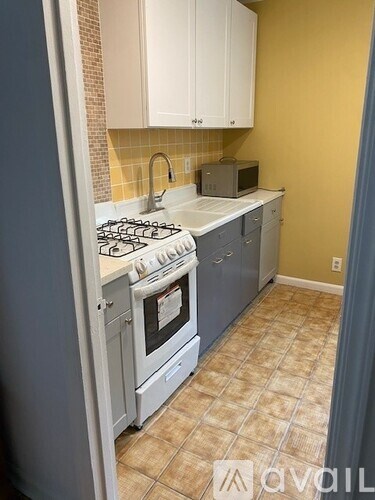 A kitchen with a white stove and cabinets.