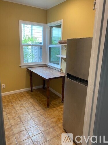 A kitchen with yellow walls, a table, and a refrigerator.
