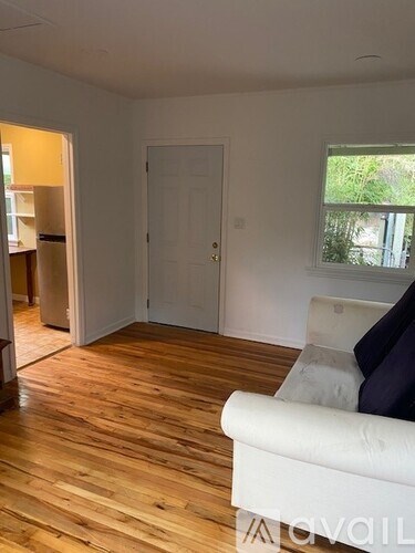 A living room with a white couch and a wooden floor.
